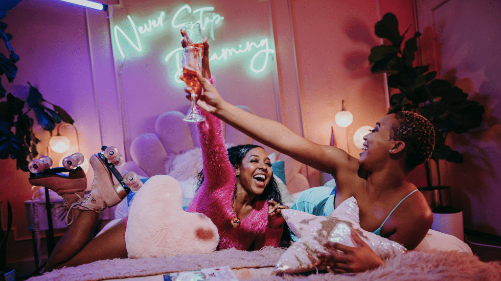 Two women enjoying a lively moment in a vibrant, colorful room