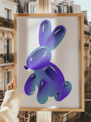 Framed Pop Art balloon animal bunny print in bright purple and teal, held up against a Parisian balcony backdrop.