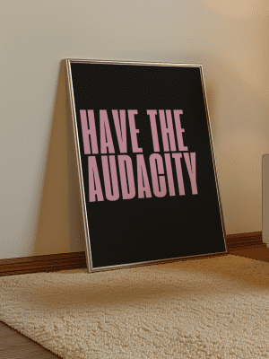 Framed motivational poster with the phrase 'Have the Audacity' in bold pink text, styled in a contemporary bedroom.