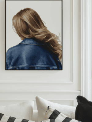 A minimalist art print of a woman with long wavy blonde hair seen from behind, wearing a classic blue denim jacket against a plain white background.