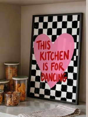 This Kitchen Is For Dancing wall art print with pink heart typography on black and white checkerboard background styled in a modern kitchen.